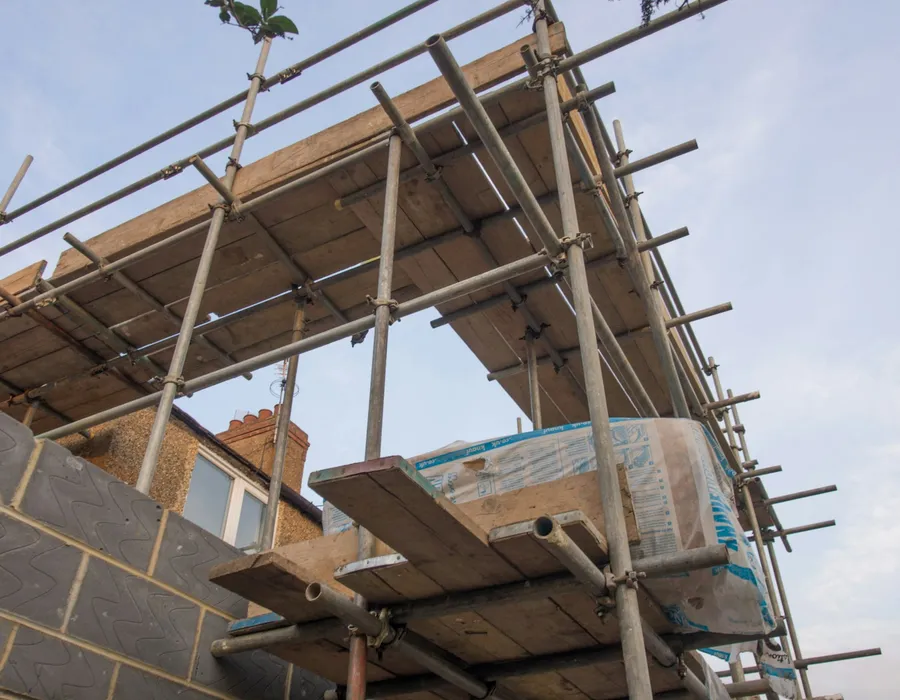 Scaffolding erected against the side of a brick house
