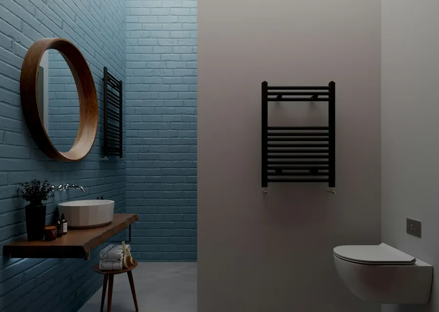 Dark tiled bathroom with a round mirror, wall-hung basin and heated towel rail