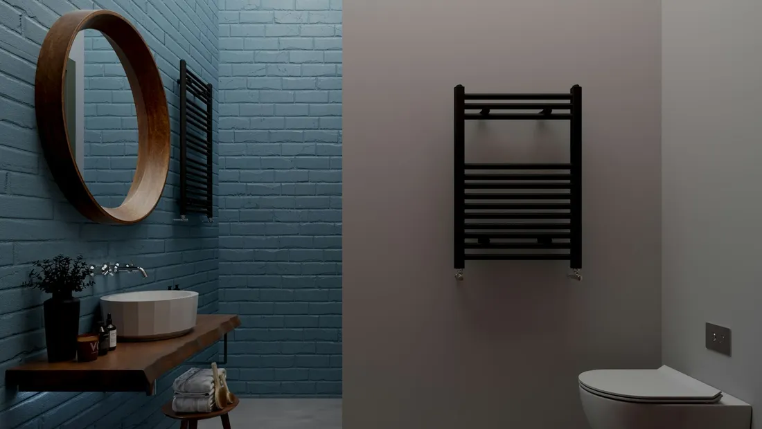 Dark tiled bathroom with a round mirror, wall-hung basin and heated towel rail