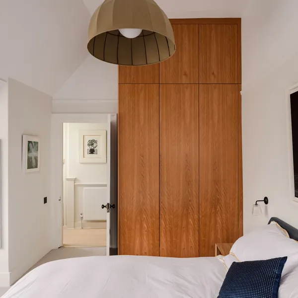 Bedroom with a full-height walnut wardrobe built in under the eaves