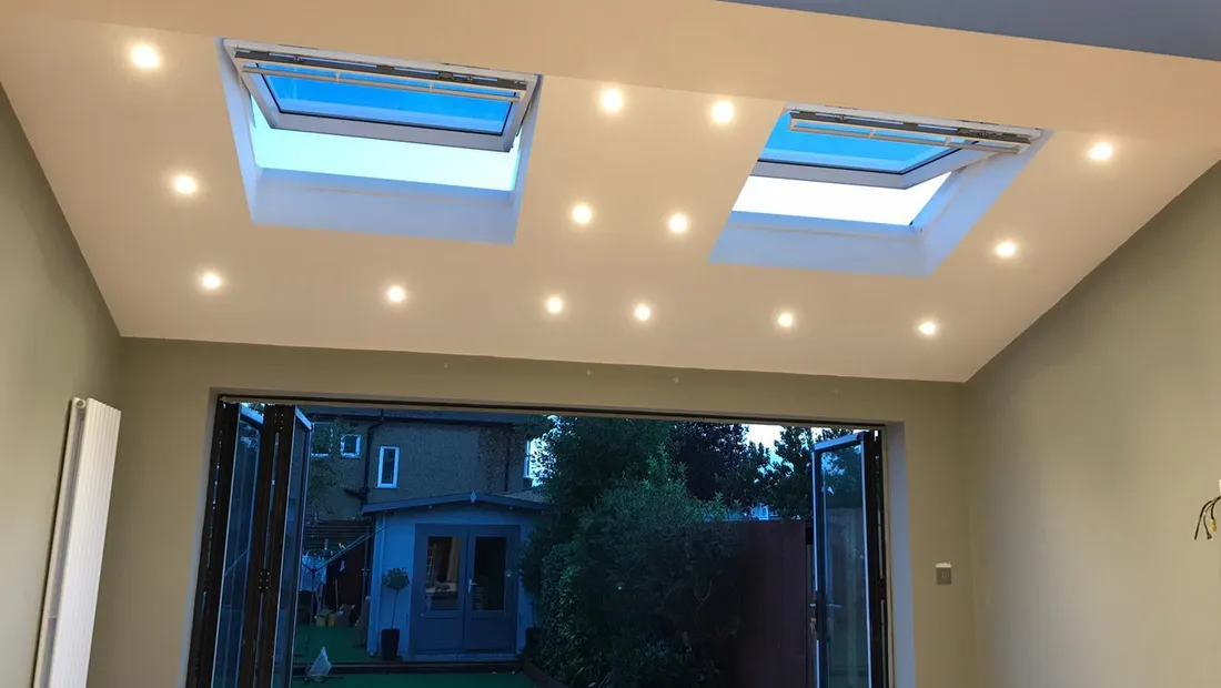 Inside a finished single-storey rear extension, with two opening rooflights, recessed downlights and bifold doors to the garden