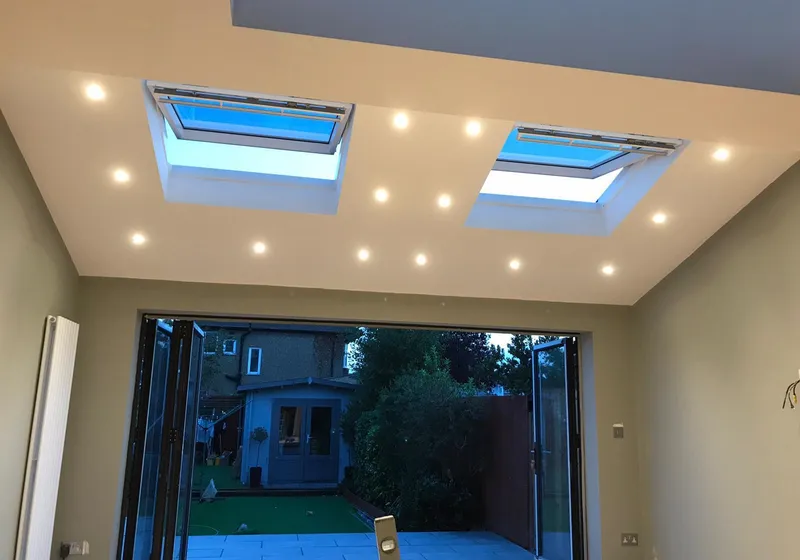 Inside a finished rear extension, with two rooflights in the ceiling and bifold doors open to the garden