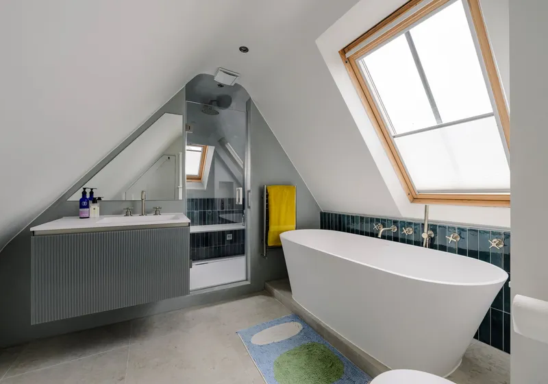 Loft bathroom with a freestanding bath under a roof window